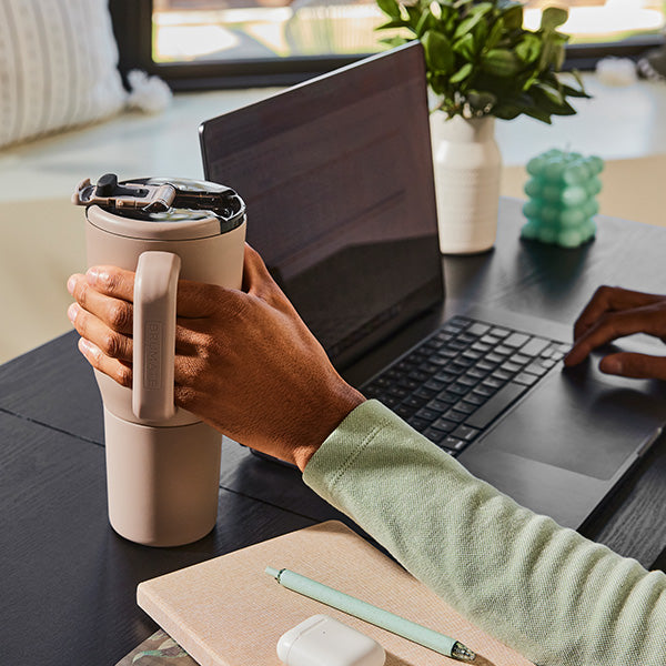 Man reading on laptop with Müv 35oz Mug